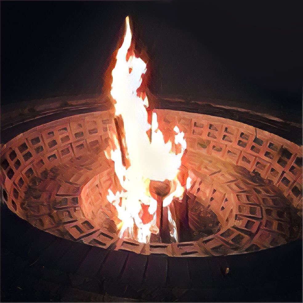 a large fire pit with a wooden chair engulfed in flames